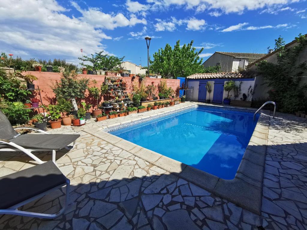 - une piscine dans un jardin avec des chaises et des plantes dans l'établissement Villa with pool near sea and garrigue, à Cournonterral