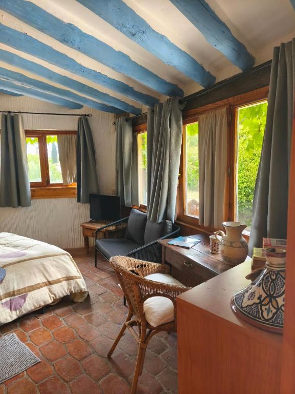 1 dormitorio con techo azul, cama y sofá en Hotel La Posada de Lalola, en Buera