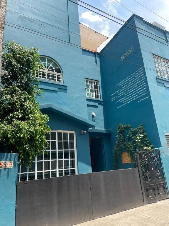 a blue building with a sign in front of it at Uotan in Mexico City