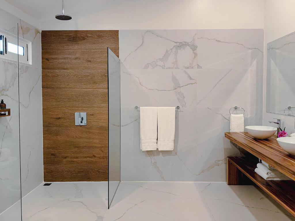 Un baño con ducha de cristal y pared de mármol. en Cloud Forest Lodge, en Monteverde