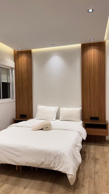 una camera da letto con due letti con lenzuola bianche di Appartement a tanger 7 min de la gare TGV et Malabata En Voiture pour famille, for family , INTERDIT COUPLES ARAABIC NON MARIÉ, FORBIDDEN UNMARRIED ARAABIC COUPLES a Tangeri