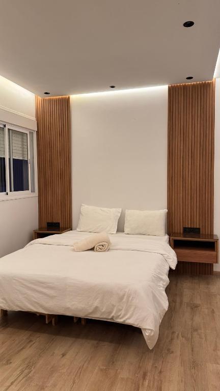 una camera da letto con un grande letto con lenzuola bianche di Appartement a tanger 7 min de la gare TGV et Malabata En Voiture pour famille, for family , INTERDIT COUPLES ARAABIC NON MARIÉ, FORBIDDEN UNMARRIED ARAABIC COUPLES a Tangeri