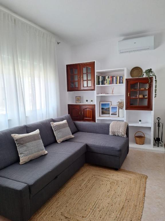 a living room with a gray couch and a rug at Casa da Vila - Malhadais in Odeceixe