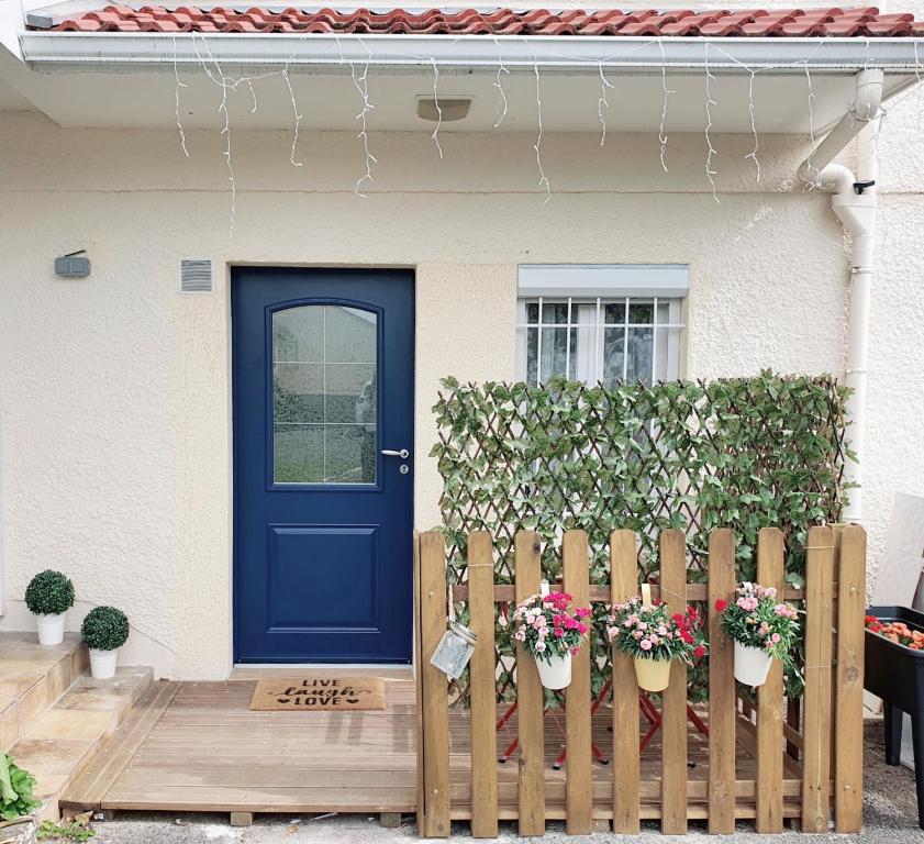 une porte bleue sur une maison avec une clôture dans l'établissement T2 NEUF - 8min de Lyon - Parking privé -Terrasse, à Irigny