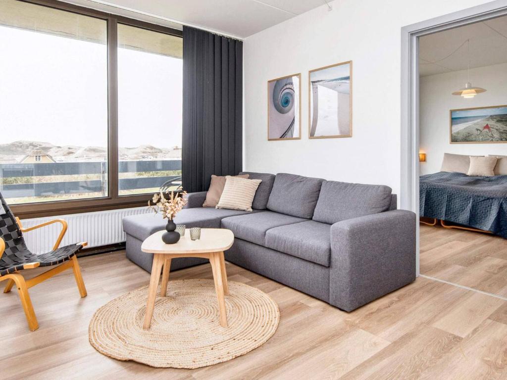 a living room with a couch and a table at Apartment in Holiday park- shared kitchen in Ulfborg