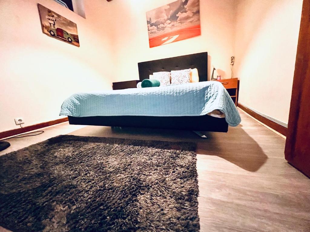 リスボンにあるLisbon Alcantara LXのベッドルーム1室(ベッド1台、青い掛け布団、ラグ付)