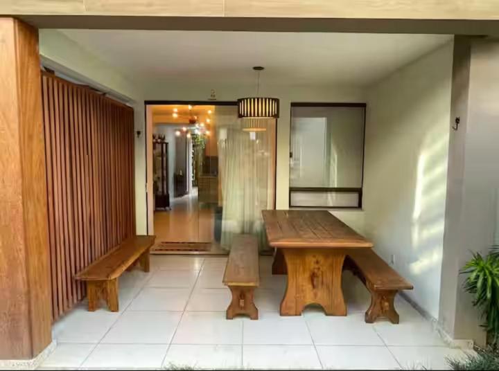 a wooden table and benches in a room at Village itacimirim completo in Camacari