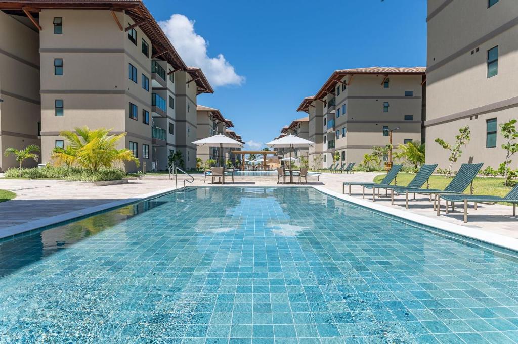 ein Schwimmbad vor einem Gebäude in der Unterkunft Itah Residence Muro Alto Beira Mar in Ipojuca