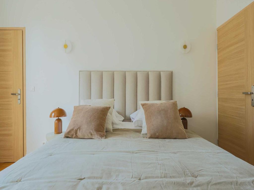 un grand lit blanc avec deux oreillers dessus dans l'établissement Charming flat -1BR-4P- Paris 17e, à Paris