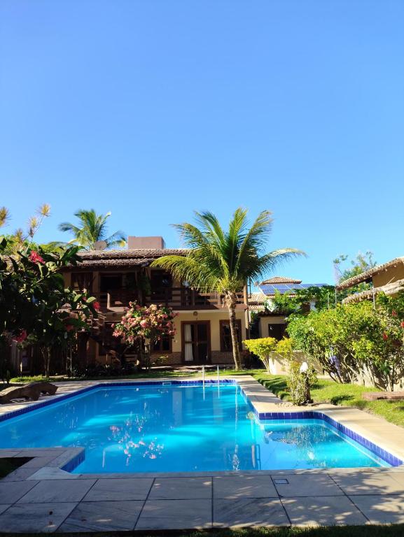 a swimming pool in front of a house at Pousada Royale in Arraial d'Ajuda