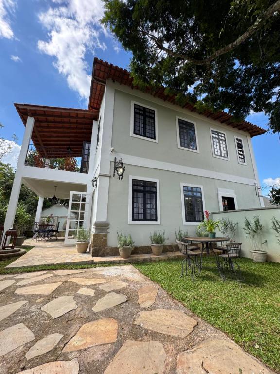 Casa bianca con patio e tavolo di Casas Petite Province Tiradentes refúgio ao pé da Serra a Tiradentes