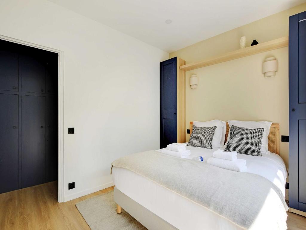 - une chambre avec un grand lit blanc et des portes bleues dans l'établissement Magnificent 2BD 6P apartment - Eiffel Tower, à Paris