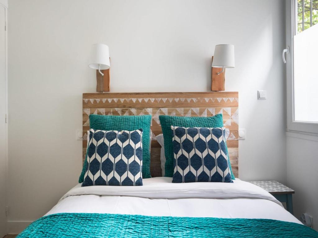 une chambre avec un lit avec des oreillers bleus et blancs dans l'établissement Charming apartment 2BR 6P - Place d'Italie, à Paris