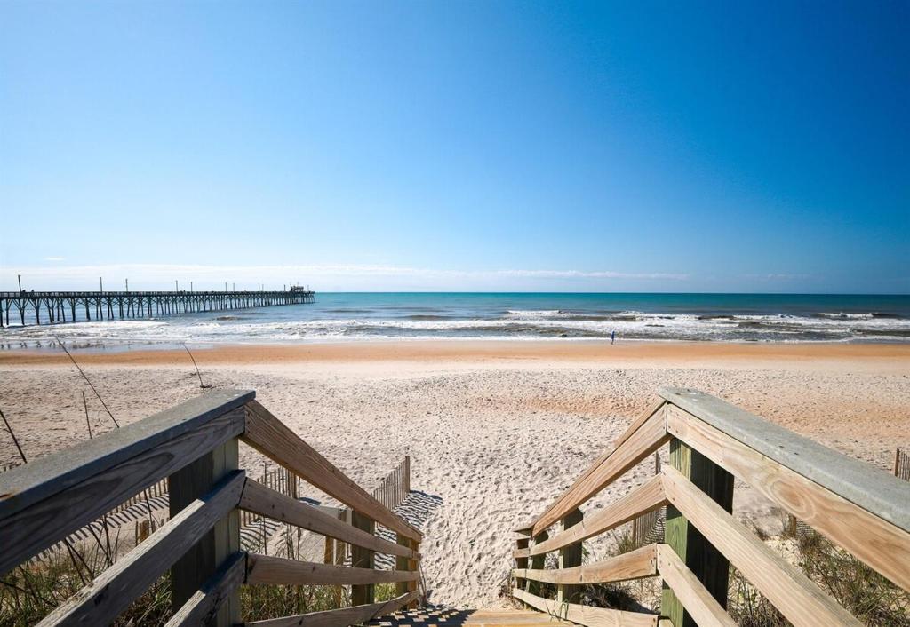 a staircase leading to a beach with a pier at Paradise between ocean and sound -A Writers Reef in North Topsail Beach