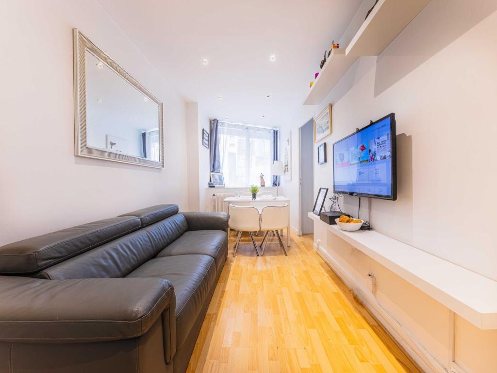 un salon avec un canapé et une télévision à écran plat dans l'établissement Quiet apartment - 1BR 4P - Sacré Coeur, à Paris