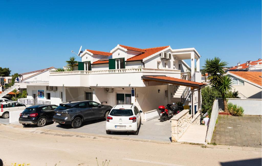 une maison blanche avec des voitures garées sur un parking dans l'établissement 2 Bedroom Lovely Apartment In Hvar, à Hvar