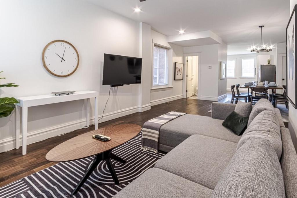 a living room with a couch and a clock on the wall at Ann Avenue Modern 3BR Home, Near Downtown with Free Parking in Saint Louis