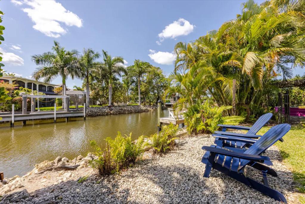 two blue chairs sitting next to a river at Waterfront Studio Just minutes to Naples Beaches in Naples
