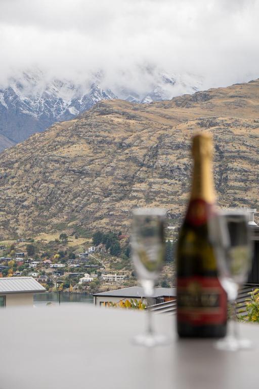 a bottle of champagne and two glasses on a table at Family Size Holiday Home With Remarkable Views & Sauna, Close to Town in Queenstown