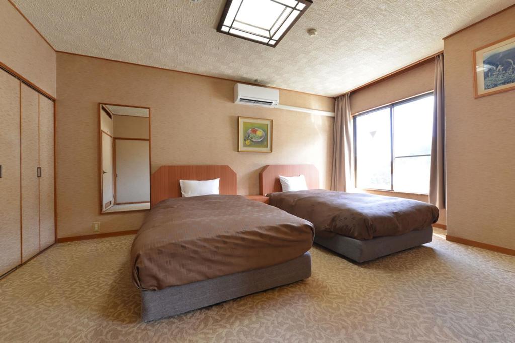 Postel nebo postele na pokoji v ubytování Ooedo Onsen Monogatari Shinshu Kakeyu