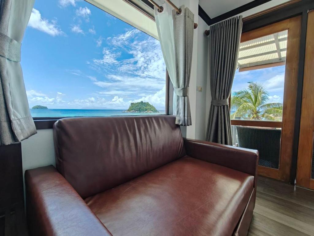 a leather couch in a room with a view of the ocean at Cabana Lipe Beach Resort in Ko Lipe