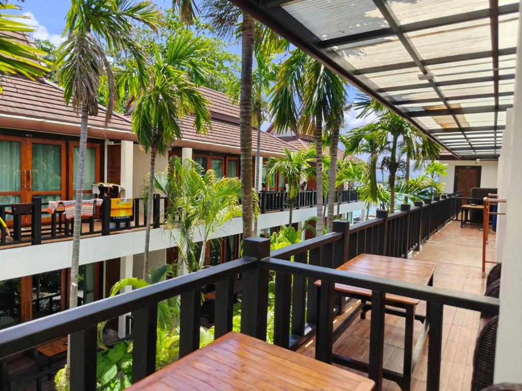 a balcony of a hotel with tables and palm trees at Cabana Lipe Beach Resort in Ko Lipe