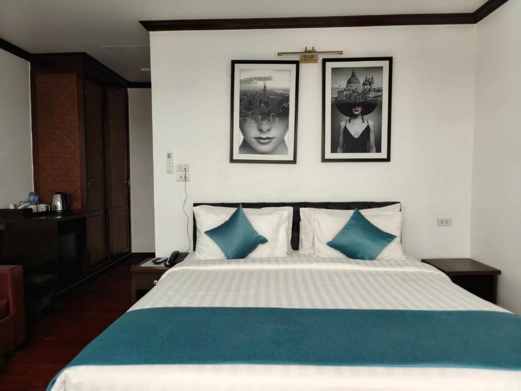 a bedroom with a large bed with blue pillows at Cabana Lipe Beach Resort in Ko Lipe