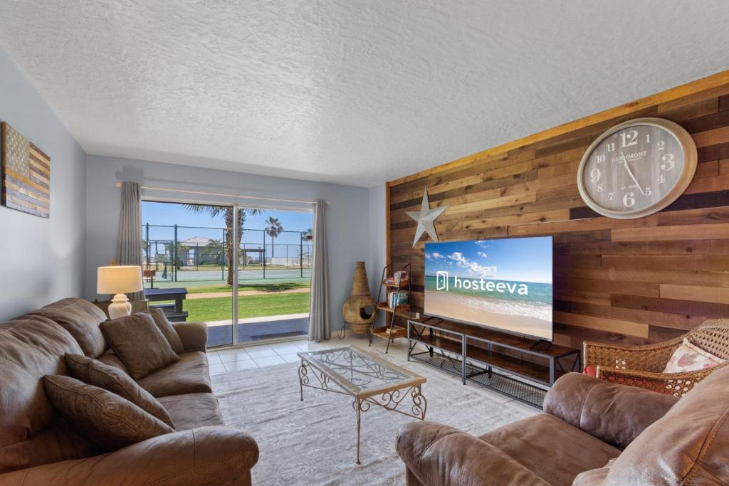 a living room with a couch and a tv at Plantation Palms 6103 in Gulf Highlands