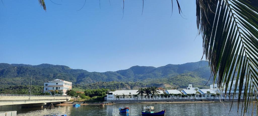 a river with a bridge and some boats in the water at Sandy Homestay-Vĩnh Hy in Ninh Hải