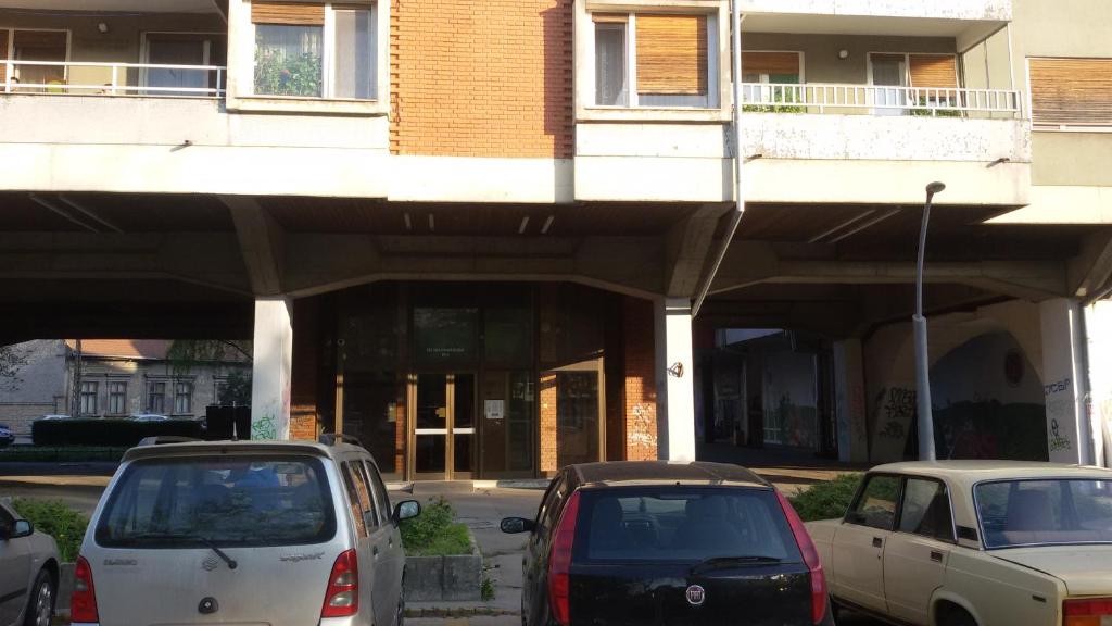 two cars parked in front of a building at Apartment Your second home in Subotica