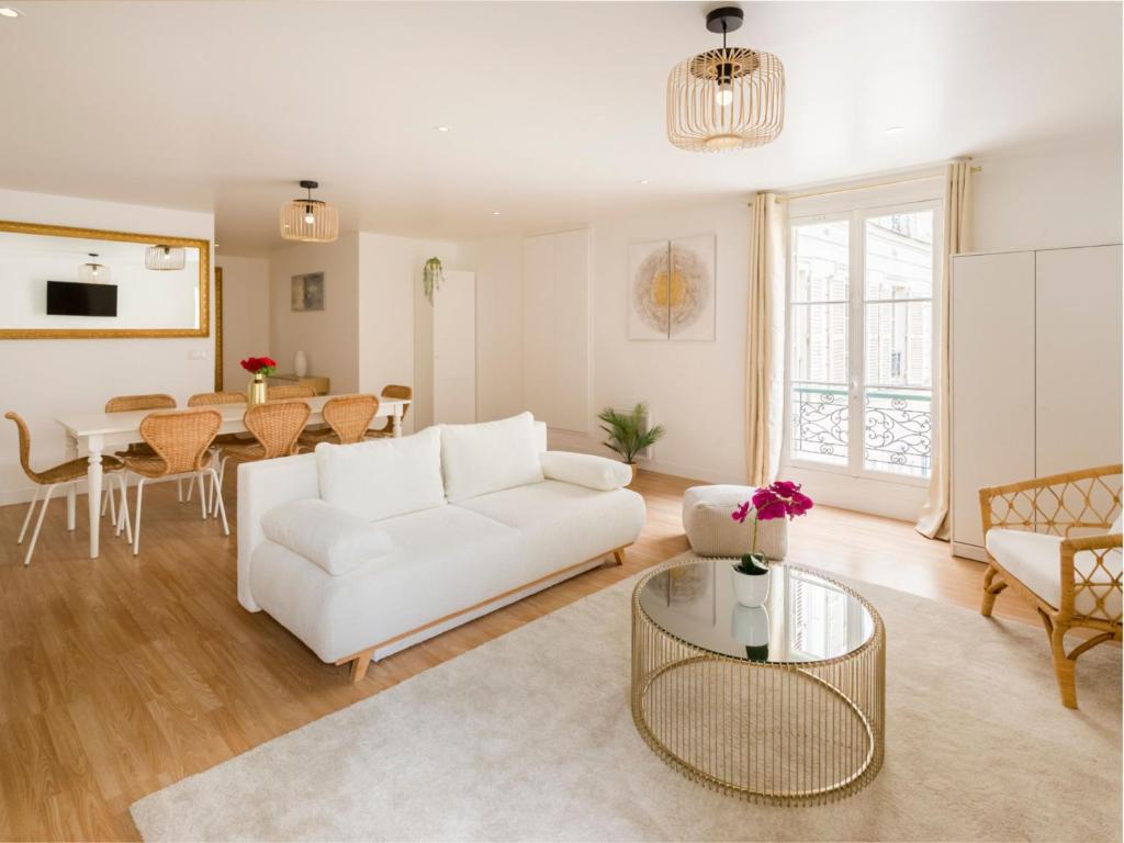 un salon avec un canapé blanc et une table dans l'établissement Merveil Family Suite - Champs Elysees - Roosevelt, à Paris