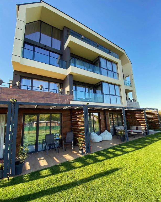 a large building with a lawn in front of it at D&N Apartments Синеморец in Sinemorets