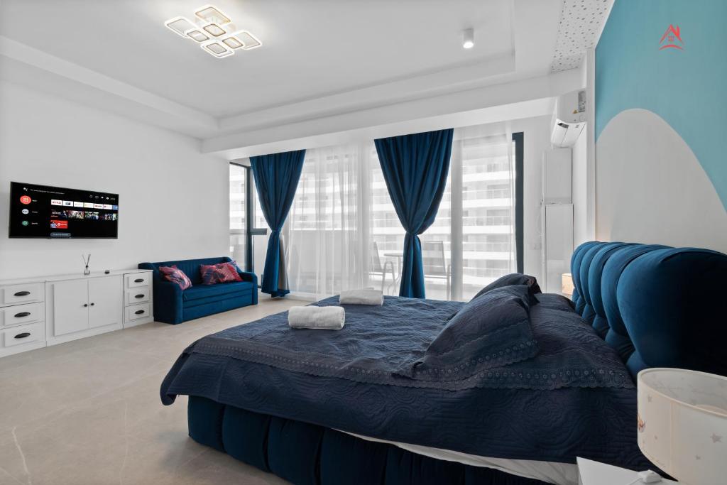 a bedroom with a blue bed and a blue couch at Studio axxis nova seaside-Parcare GRATIS in Năvodari