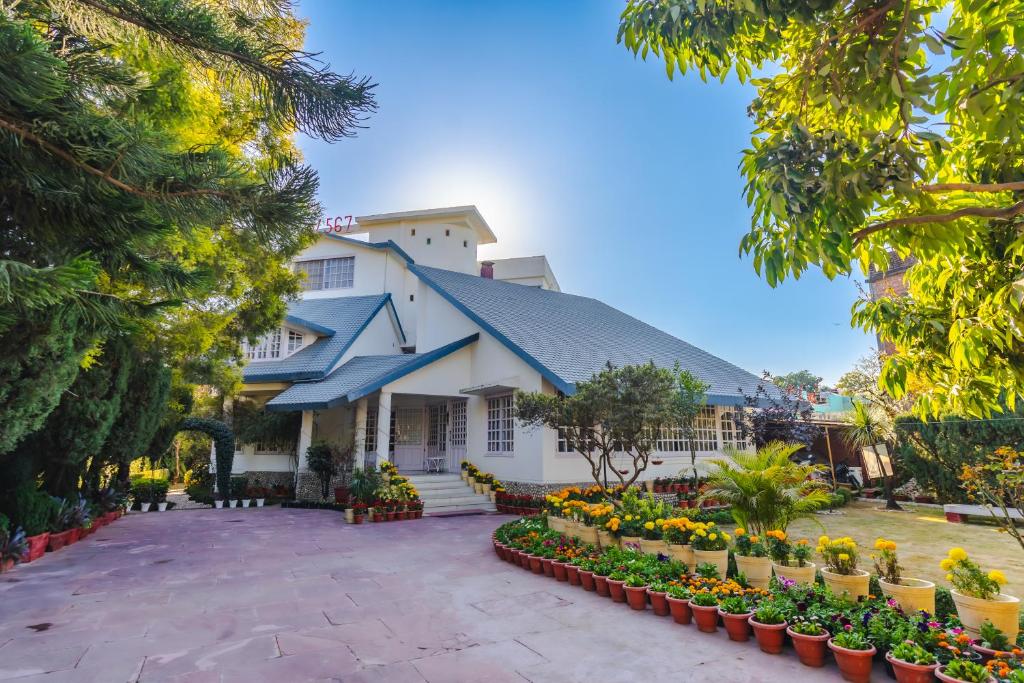 a building with flowers in front of it at Boutique Villa w Bonfire & BBQ, Mussoorie Foothills in Dehradun
