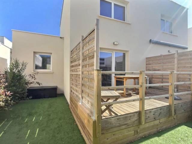 un balcon avec une clôture en bois devant une maison dans l'établissement Villa proche plage, à Sérignan