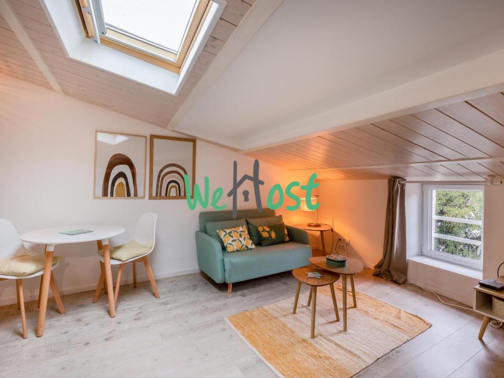 un salon avec un canapé bleu et une table dans l'établissement Atypical studio central, à La Rochelle