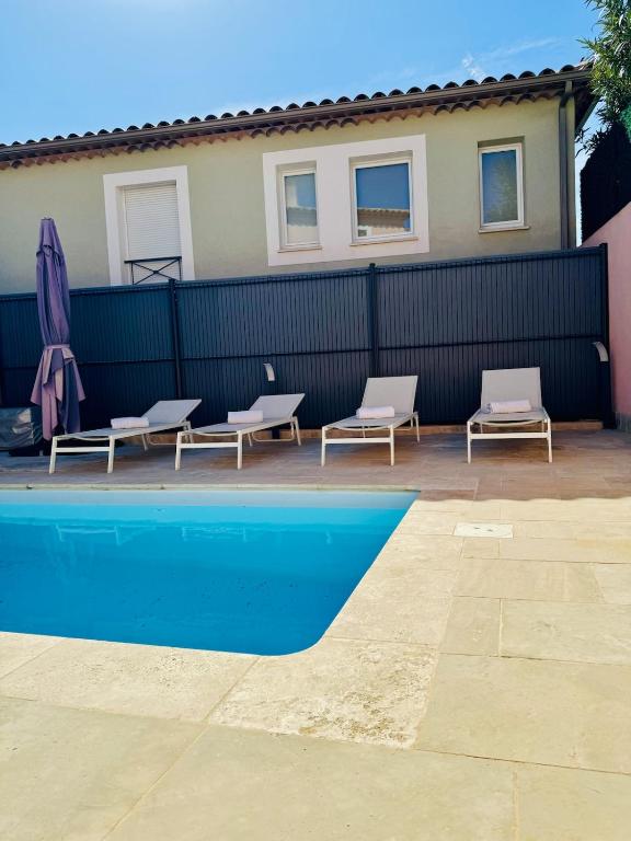 - une piscine avec 2 chaises longues et 2 parasols dans l'établissement Villa San Peire Private pool close sea, à Roquebrune-sur Argens