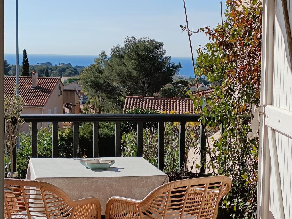 une table blanche et des chaises sur un balcon dans l'établissement Bleu d' Azur, 4 pers vue mer, gare et coeur de ville 20mn à pied, à Saint-Raphaël