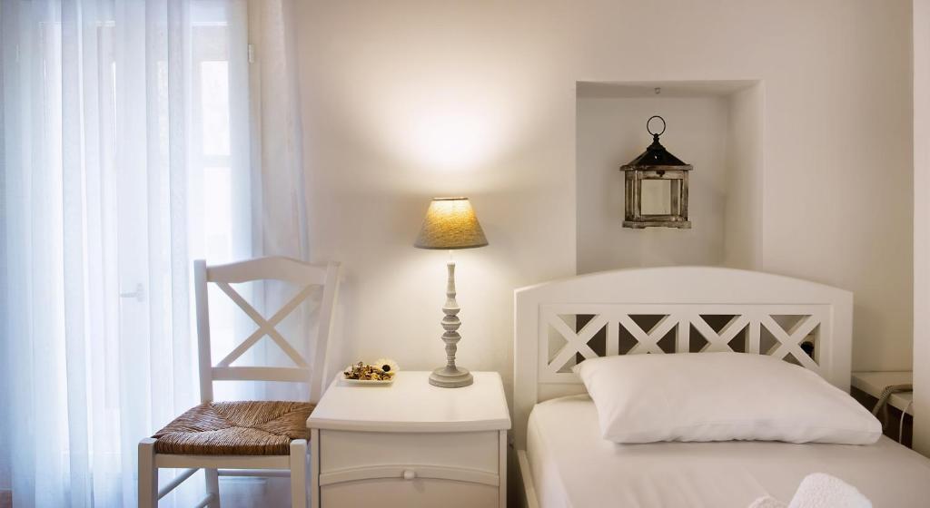 ein Schlafzimmer mit einem Bett, einem Tisch und einem Stuhl in der Unterkunft Ontas Traditional Hotel in Chania