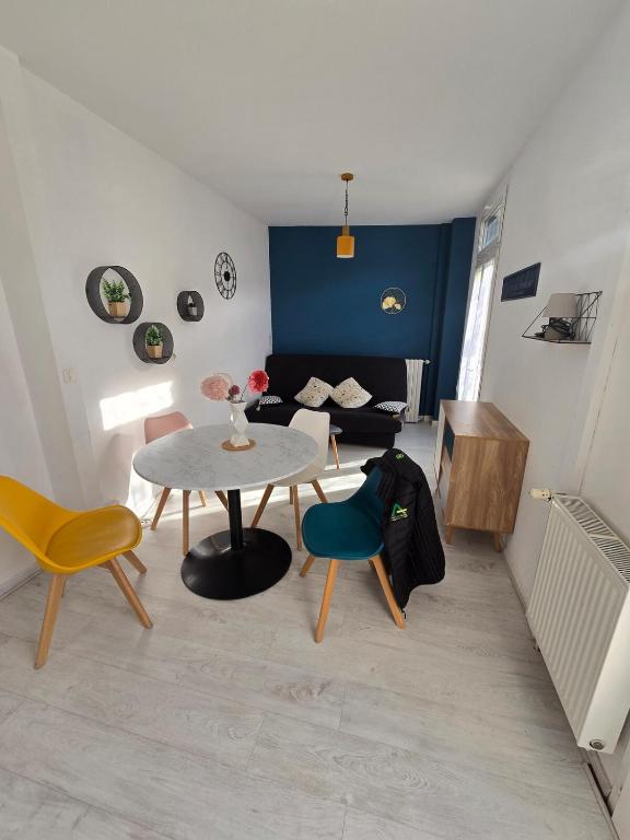 un salon avec une table, des chaises et un canapé dans l'établissement Appartement en RDC, lumineux et spacieux vue sur la montagne, à La Bourboule