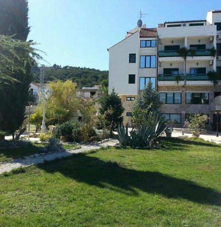a large building in front of a field of grass at Hotel Vila Marco Polo in Slatine