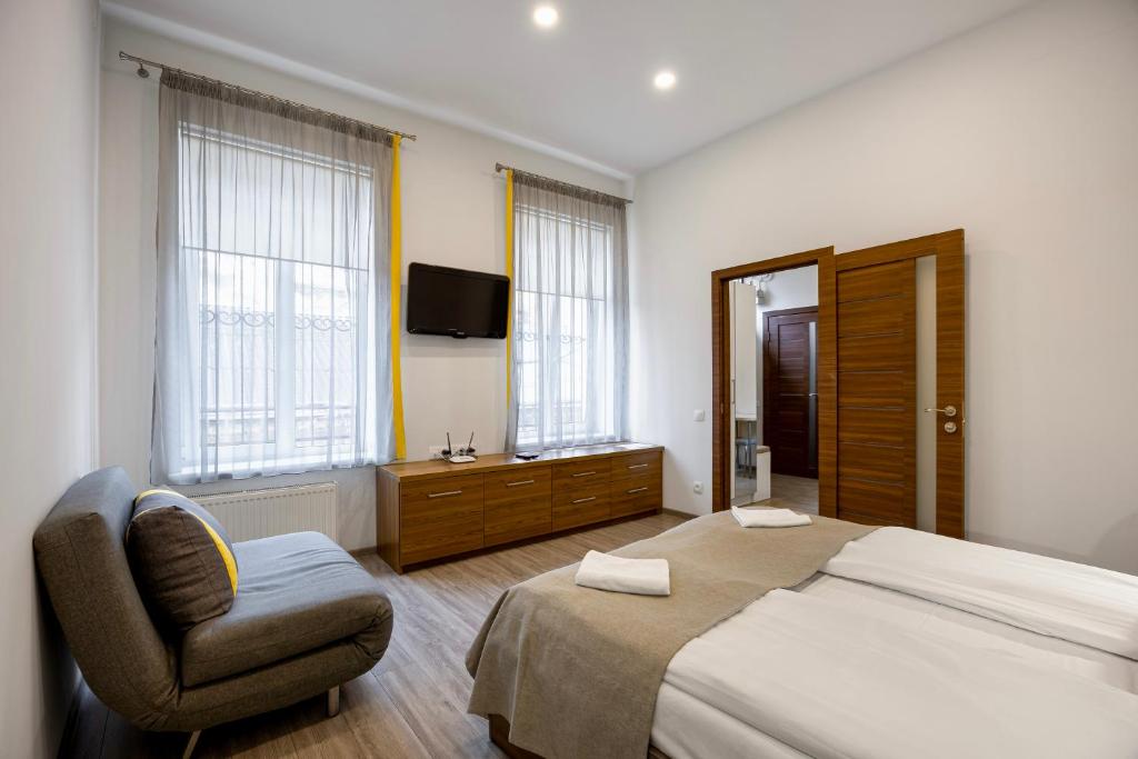 a bedroom with a bed and a chair and a television at Апартаменти на Площі Ринок 12 in Lviv