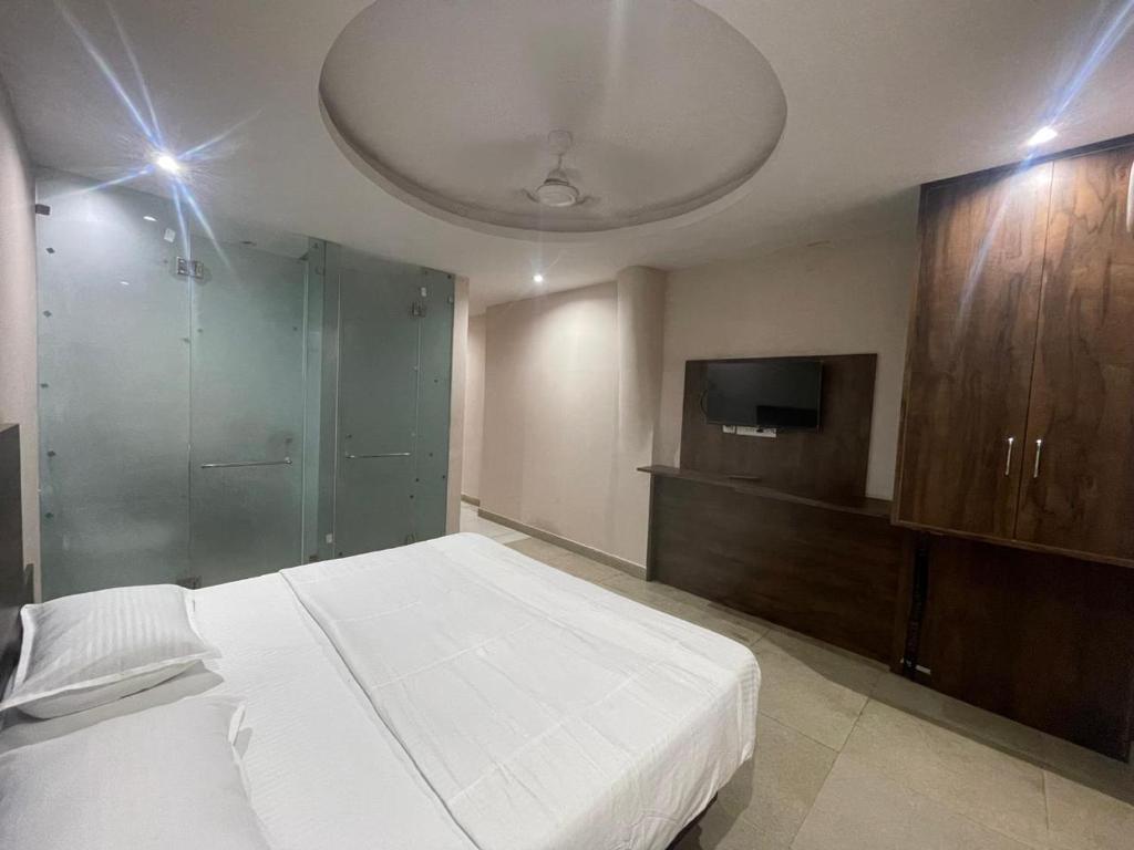 Un dormitorio con una cama y un televisor de pantalla plana. en Grand Darbar, en Bānda