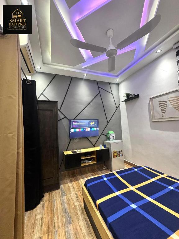 a room with a ceiling fan and a tv at SMART BÂTIPRO Studio 2 in Cotonou