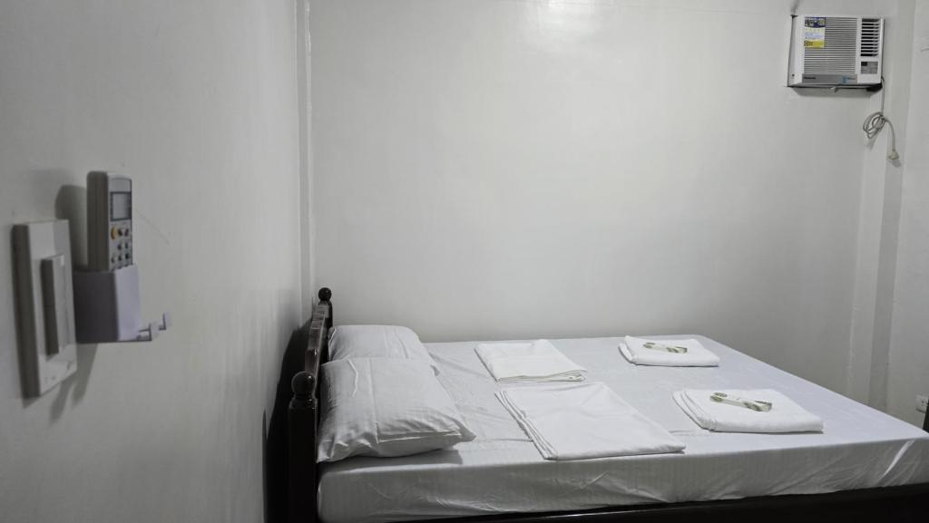 a bed with two towels on it in a room at Jam Residences in Tagbilaran City