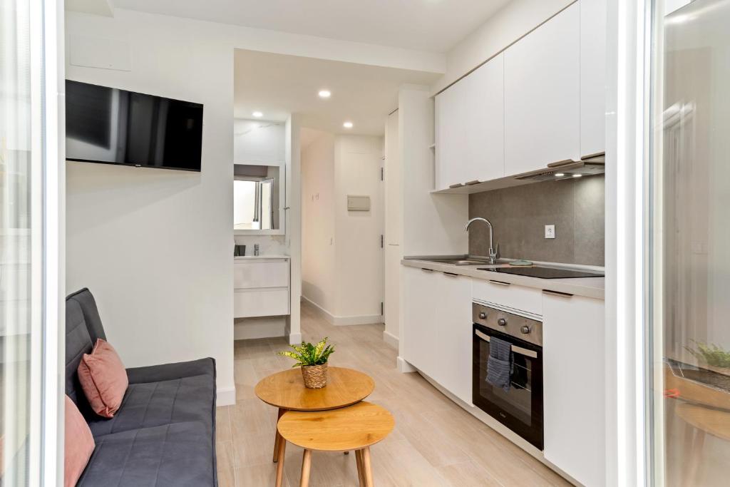 a kitchen and living room with a couch and a table at Cala Azul-few steps from the beach in La Cala de Mijas