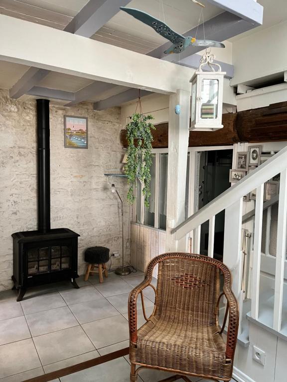 Cette chambre comprend une chaise en osier et un poêle à bois. dans l'établissement Maison de pays coeur de village, à Sainte-Marie de Ré