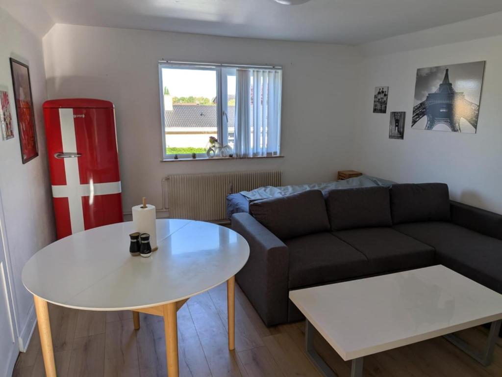 ein Wohnzimmer mit Sofa und Tisch in der Unterkunft Pet-Friendly Apartment 1 30m2 - close to Femern & Puttgarden & Lalandia & Knuthenborg in Holeby