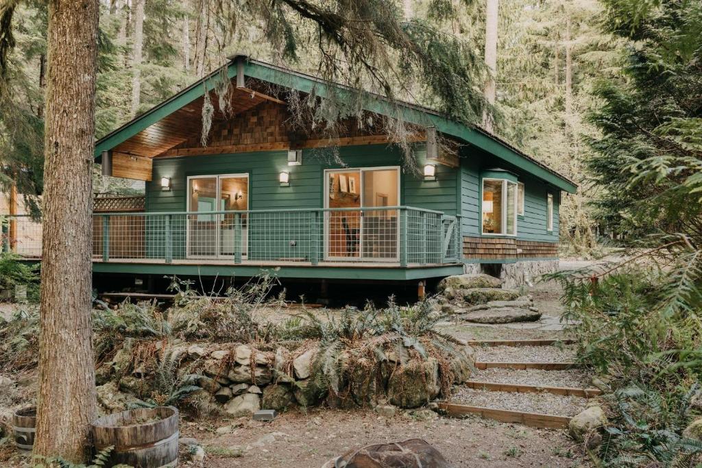 a green house in the middle of a forest at Glacier Springs Cabin 2bedrooms 60 The Family Time Cabin in Deming