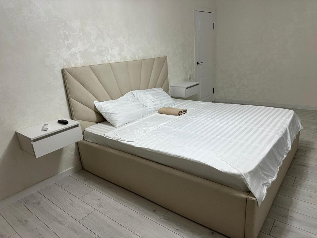 Ένα ή περισσότερα κρεβάτια σε δωμάτιο στο Уютные апартаменты на площади Аль-Фараби-SHYMKENT PLAZA